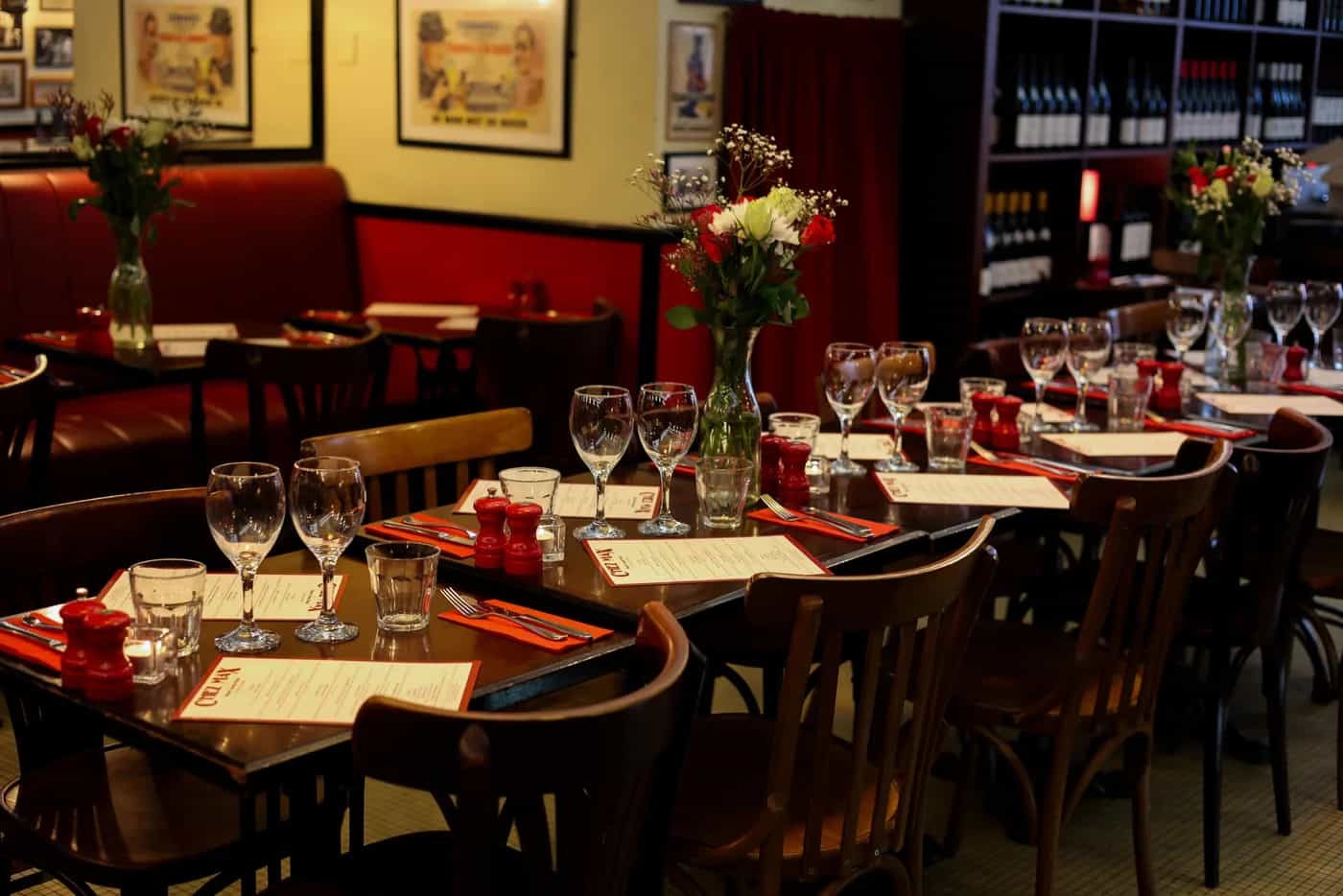 Salle du restaurant Chez Max, tables dressées et banquettes rouges