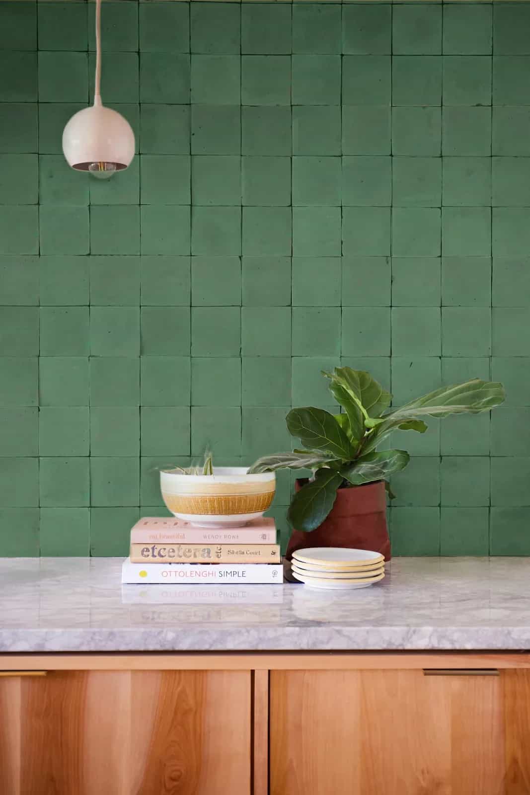 Mur de carreaux verts Gwilen au-dessus d'un comptoir en pierre et bois