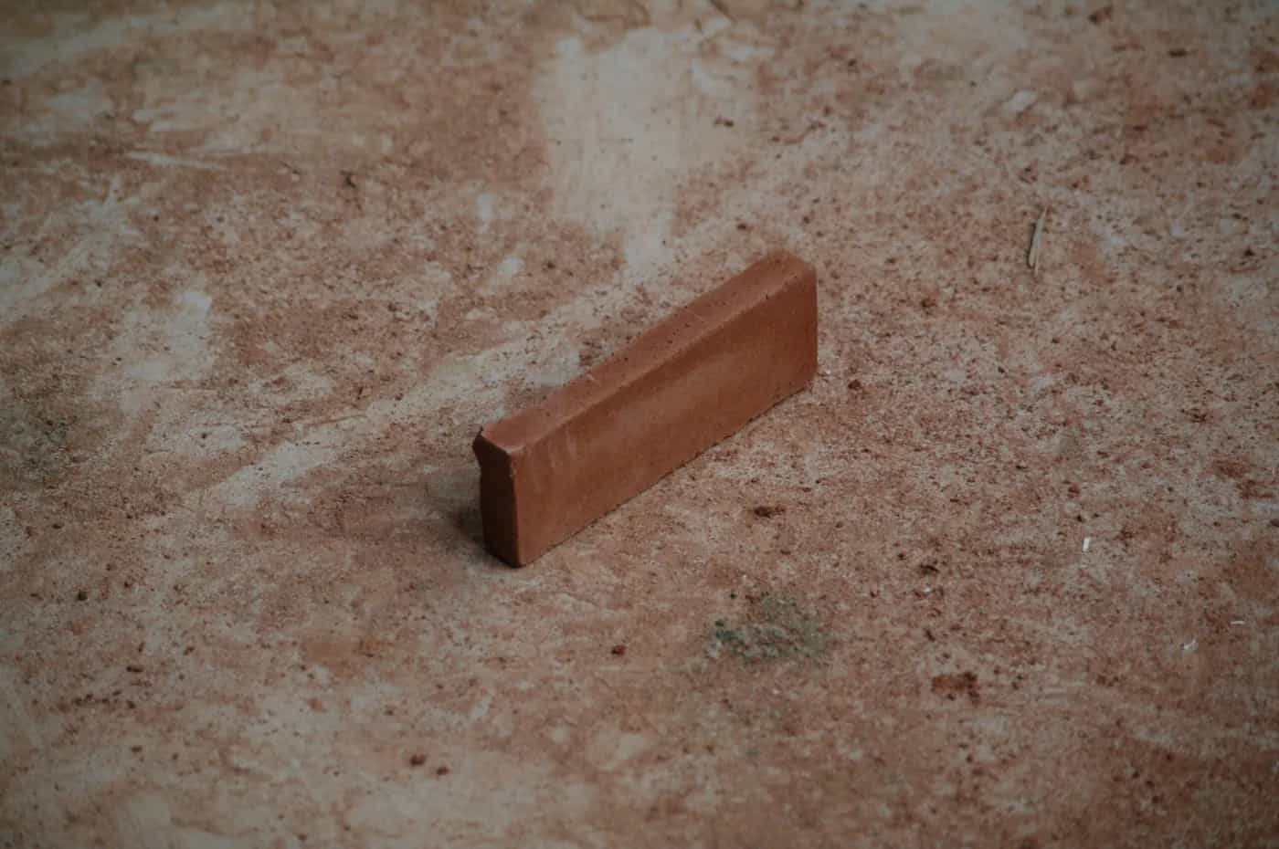 Gros plan sur un élément en sédiment marin pressé posé sur une surface minérale